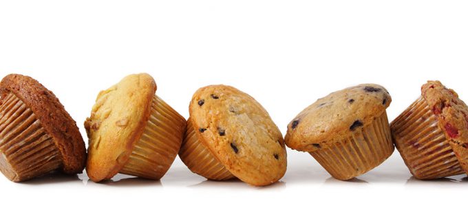 Fresh plump muffins topping over on a white countertop
