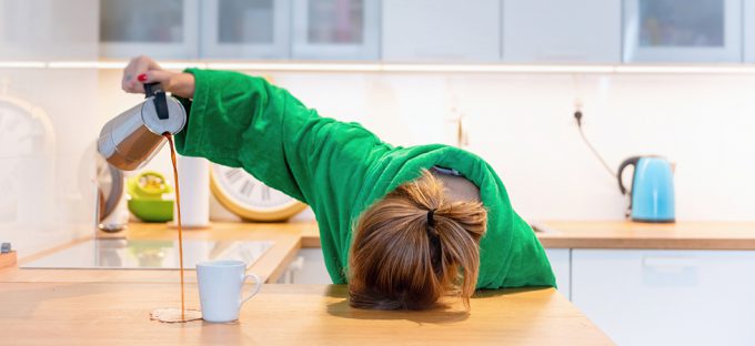 Sleep Deprived woman pouring coffee onto counter top