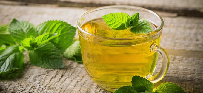 Cup of peppermint tea on wooden table